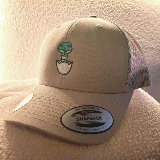 Custom beige BabySNEK trucker hat with snapback closure and stitched BabySNEK logo